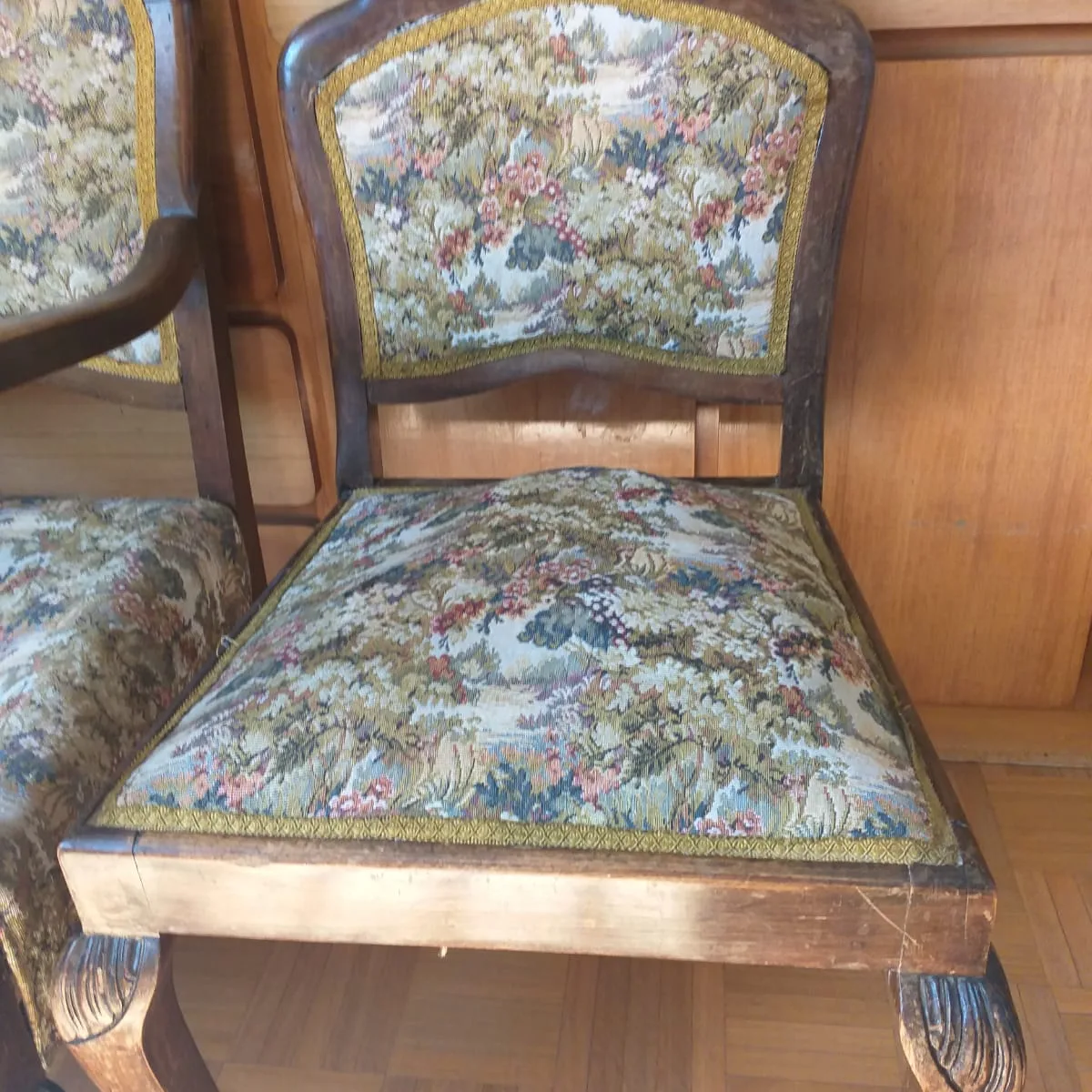 Silla restaurada con tela floral verde y bordes dorados