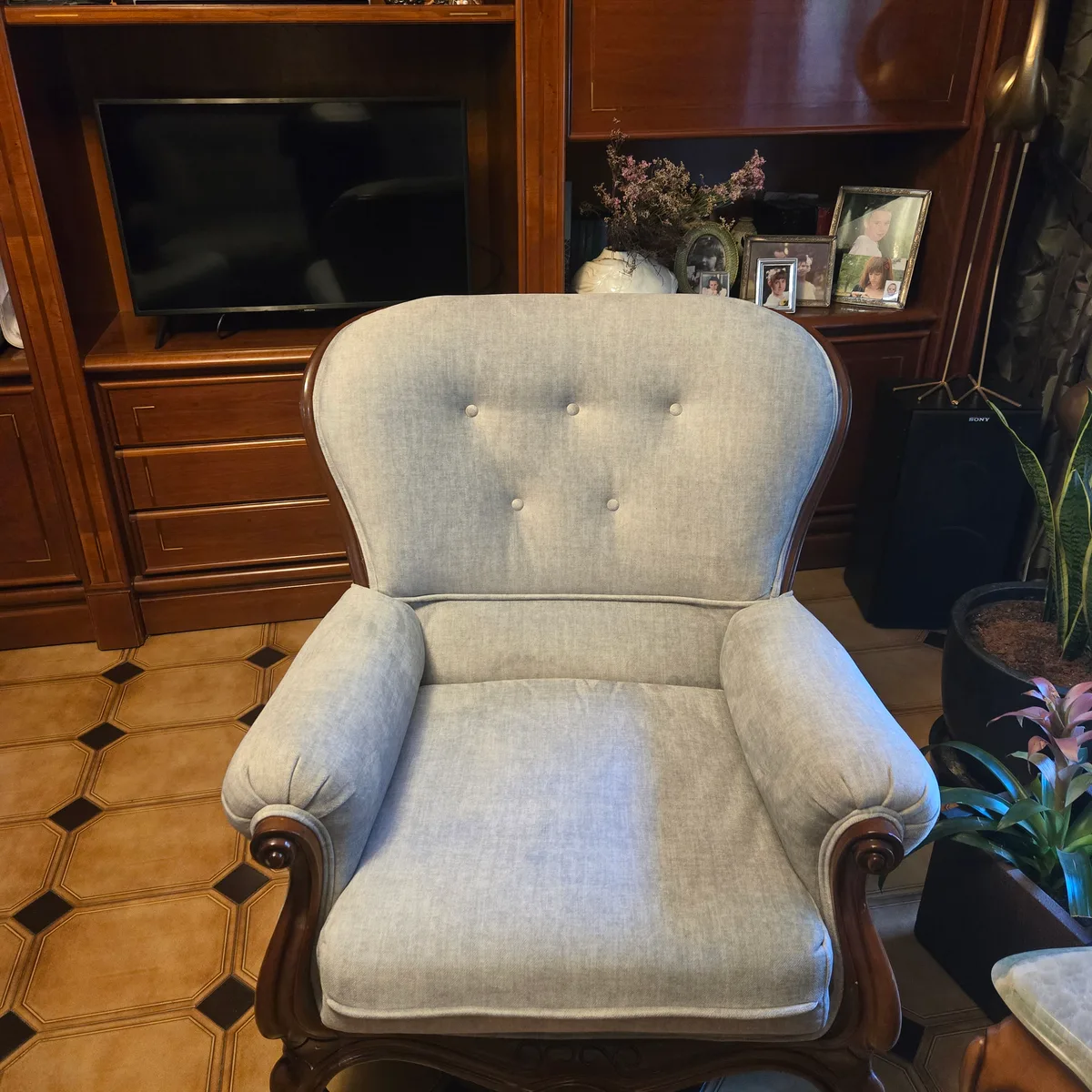 Sillón provenzal tapizado en gris claro a juego con el sofá