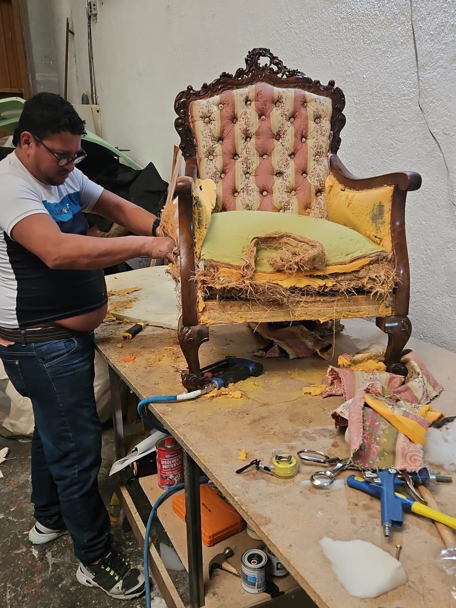 Tapicero de Tapicería Junquera trabajando una silla en el taller