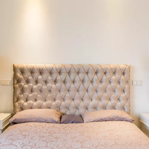 Tapizado de un cabecero de cama en color oro.